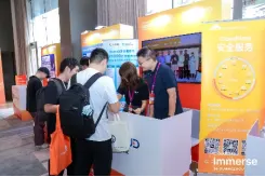 参会者在橙白配色展台前咨询交流