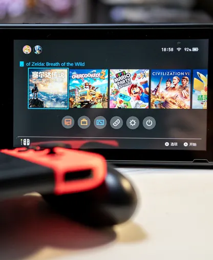 游戏客户案例配图：桌面上的 Switch 游戏机与虚化的 Joy-Con 手柄